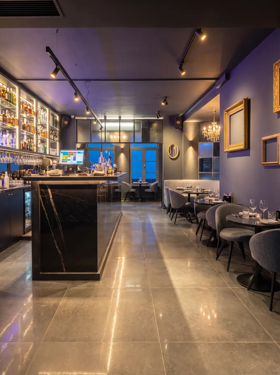 Le bar en marbre noir le soir, les cadres dorés sur le mur violet