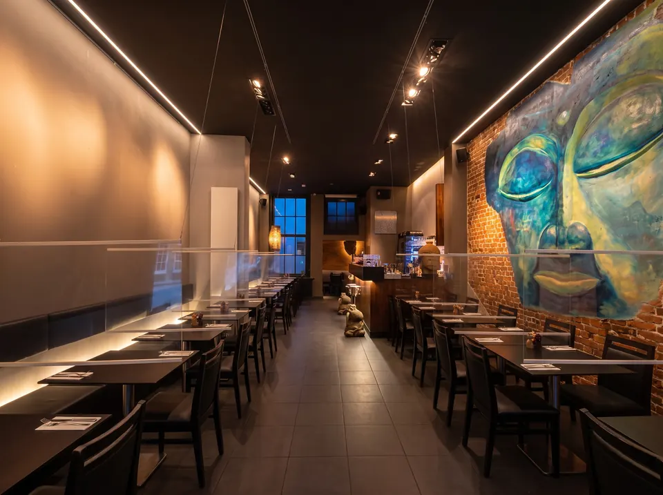 La salle du bar sous le grand Bouddha peint sur le mur de briques