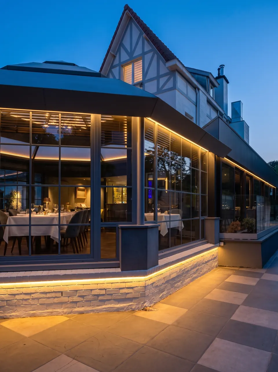 La terrasse au pied de la verrière, éclairée à l'heure bleue